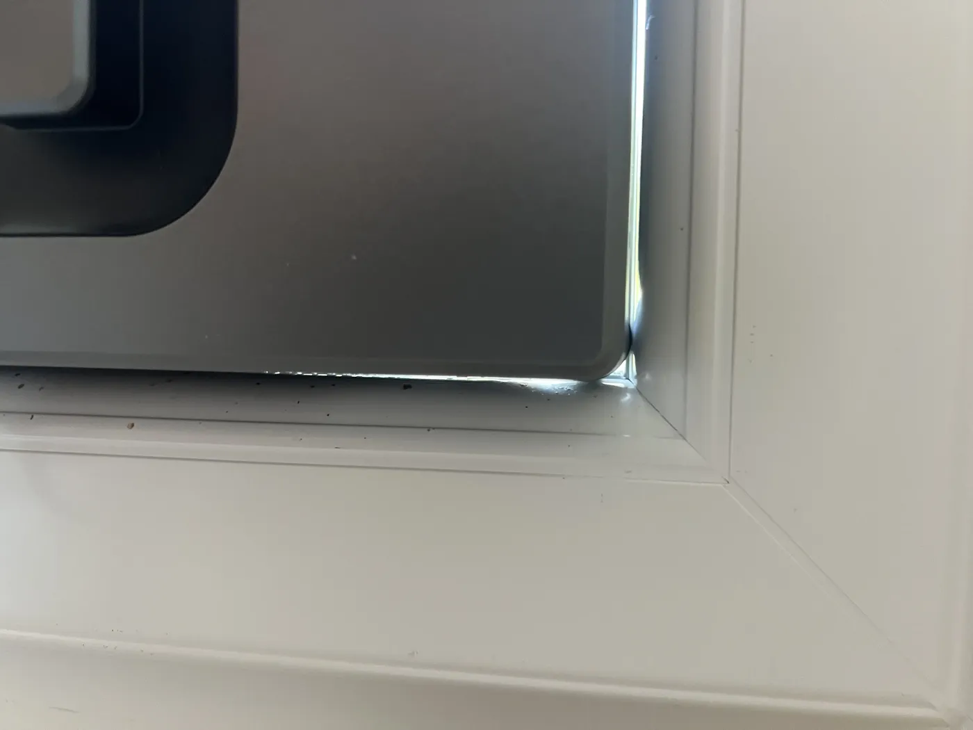 Robot lave-vitre carré en butée dans l'angle d'une fenêtre PVC