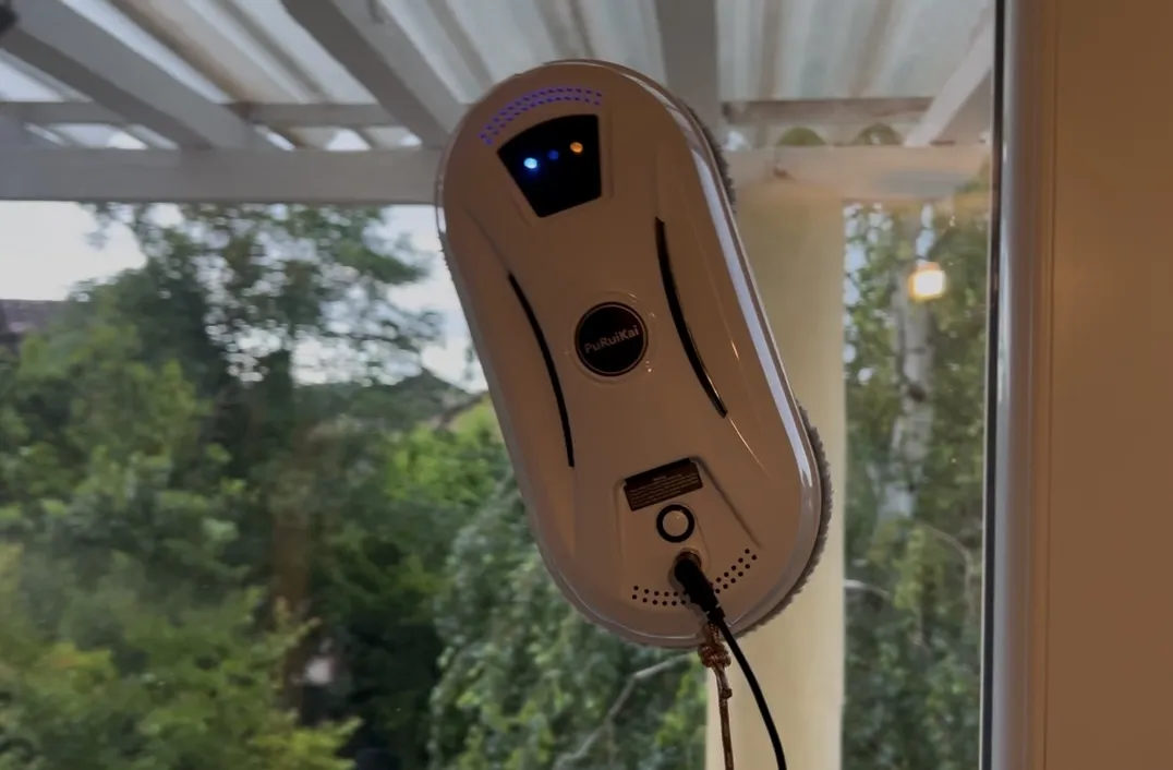 Robot lave-vitre à double disque en fonctionnement sur une fenêtre